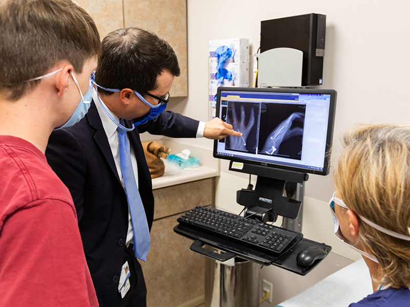 Hunter looks at his X-rays with Dr. Marc Walker and Dr. Kellie Leitch.